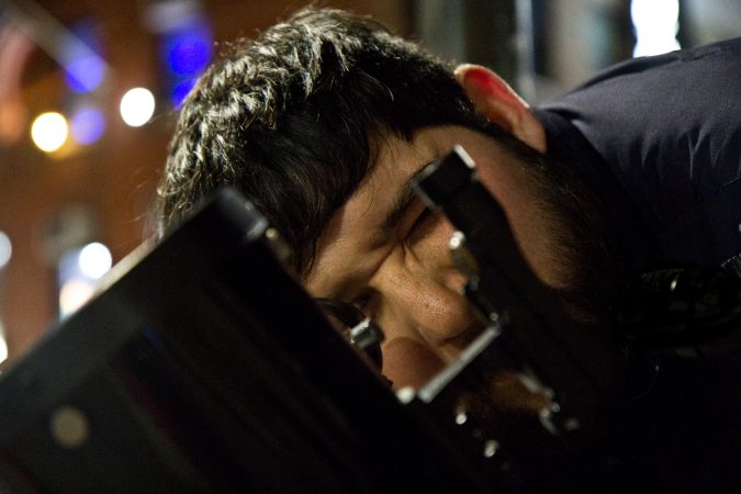 Abraham Reyes looks through a telescope on South Street. (Kimberly Paynter/WHYY)