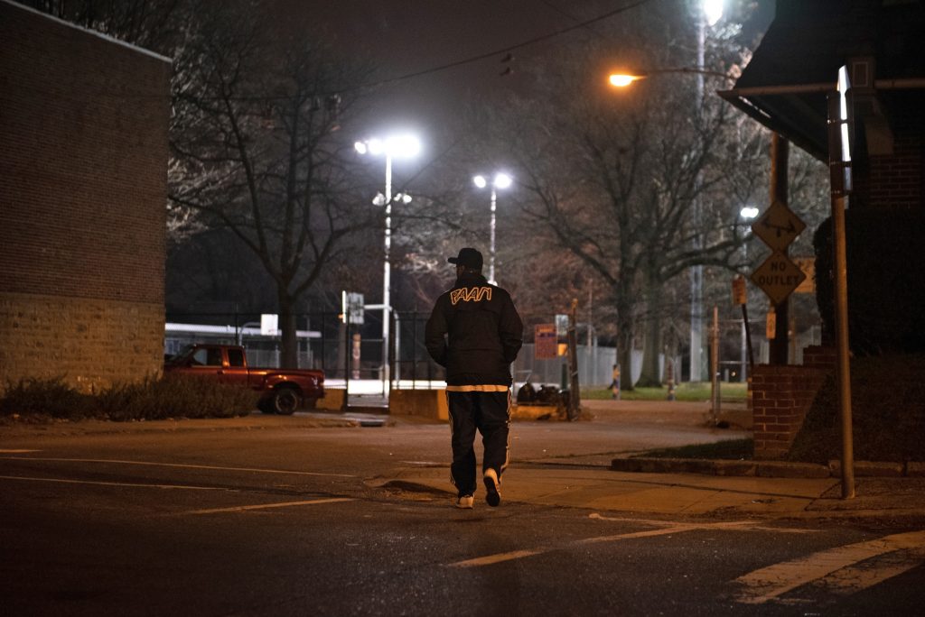 20181130_WHYY_Community Crisis Intervention Program_232 While canvassing in Olney, Tarik Harris crosses the street to survey Lindley Playground, which he says is known to be a location for selling drugs. (Kriston Jae Bethel for WHYY)