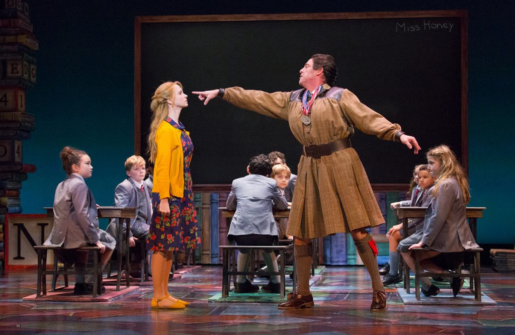 Laura Giknis as a first-grade teacher, Ian Merrill Peakes as Miss Trunchbull, and Jemma Bleu Greenbaum (far right), one of two actresses who play Matilda on different nights in the Walnut Street Theatre production of the musical 