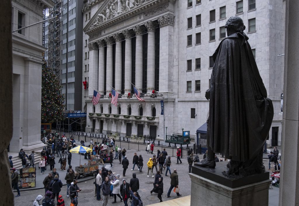 People stand near a statue of George Washington, adjacent to the New York Stock Exchange, background, Saturday, Dec. 22, 2018, at the closed Federal Hall National Memorial in New York.   Now in its 10th year, America's economic expansion still looks sturdy. Yet the partial shutdown of the government that began Saturday has added another threat to a growing list of risks. (Craig Ruttle/AP Photo)