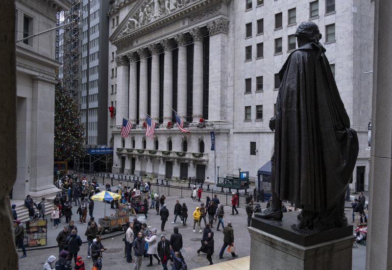 People stand near a statue of George Washington, adjacent to the New York Stock Exchange, background, Saturday, Dec. 22, 2018, at the closed Federal Hall National Memorial in New York.   Now in its 10th year, America's economic expansion still looks sturdy. Yet the partial shutdown of the government that began Saturday has added another threat to a growing list of risks. (Craig Ruttle/AP Photo)