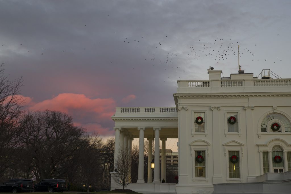 Trump Border Wall The setting sun illuminates clouds behind the White House during a partial federal shutdown, Saturday, Dec. 22, 2018, in Washington. The partial federal shutdown was expected to drag into Christmas as President Donald Trump and congressional leaders remained stuck in a standoff over his border wall with Mexico. (AP Photo/Alex Brandon)