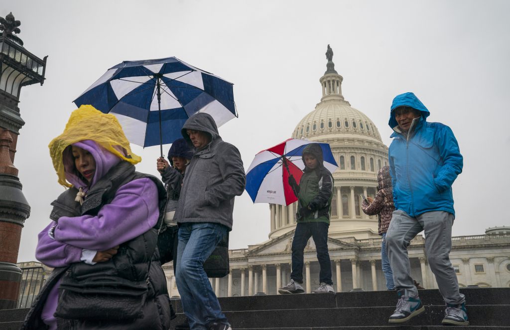 Tourists arrive to visit the U.S. Capitol on a rainy morning in Washington, Friday, Dec. 28, 2018, during a partial government shutdown. The partial government shutdown will almost certainly be handed off to a divided government to solve in the new year, as both parties traded blame Friday and President Donald Trump sought to raise the stakes in the weeklong impasse. (AP Photo/J. Scott Applewhite)