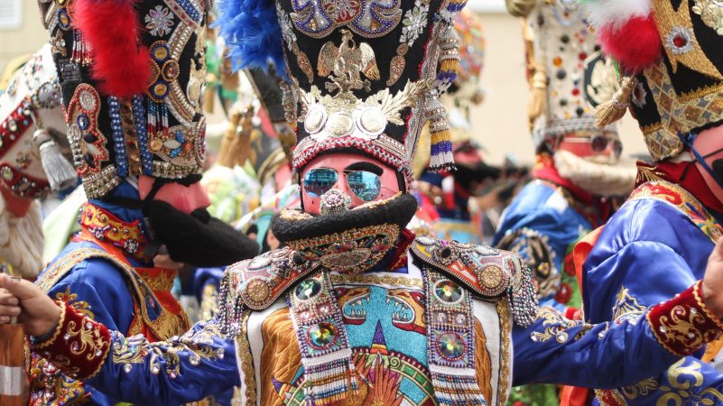 Participants in elaborate costumes dance on Washington Avenue in South Philadelphia to celebrate the annual Carnaval de Puebla on April 29, 2018. The celebration of Mexican culture and history honors Mexico's victory in the Battle of Puebla in 1862. (Angela Gervasi for WHYY)