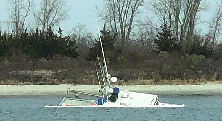 A partially submerged fishing vessel in the Manasquan Inlet Saturday morning. (Image: @thedeskchicken as tagged #JSHN on Instagram)