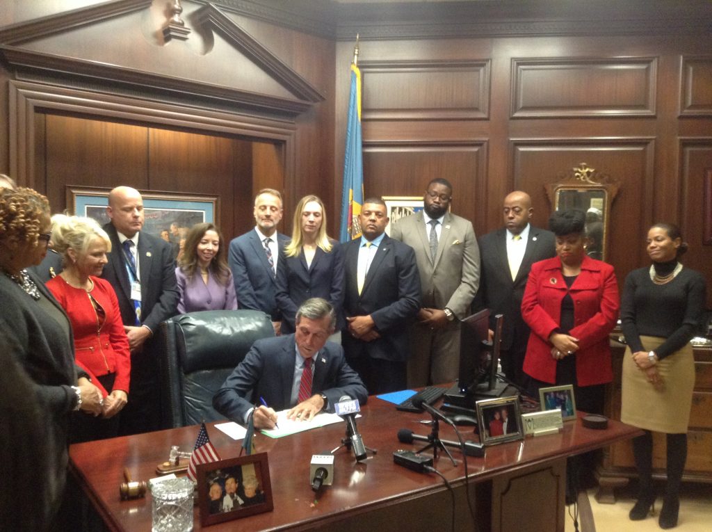 IMG_0704 Delaware Gov. John Carney signs an executive order Tuesday aimed at reducing recidivism. (Zoe Read/WHYY)