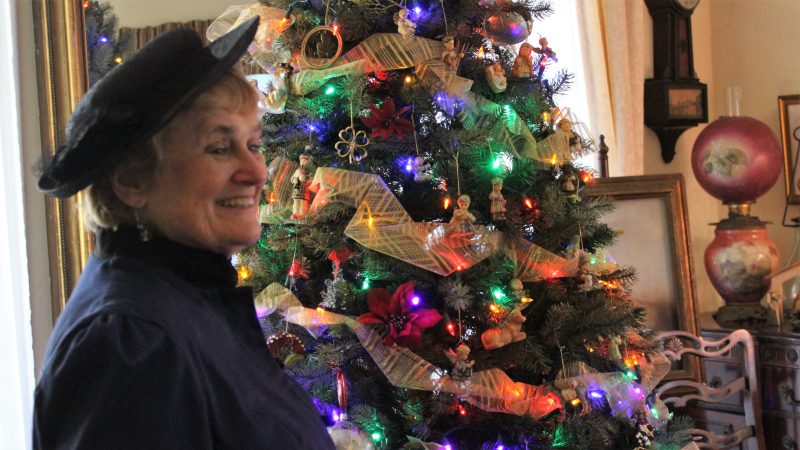 Regina Dougherty-McCarren, in Victorian costume, is ready to talk with visitors to the Twin Gables bed and breakfast  in Cape May. The inn is included on a Christmas walking tour of the city. (Bill Barlow/for WHYY)