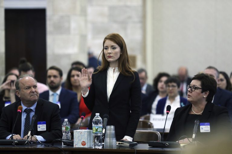 In December 2018, Katie Brennan, the chief of staff at the New Jersey Housing and Mortgage Finance Agency, raises her hand as she is sworn in to testify before the Select Oversight Committee at the Statehouse in Trenton, N.J. (Mel Evans/AP Photo)
