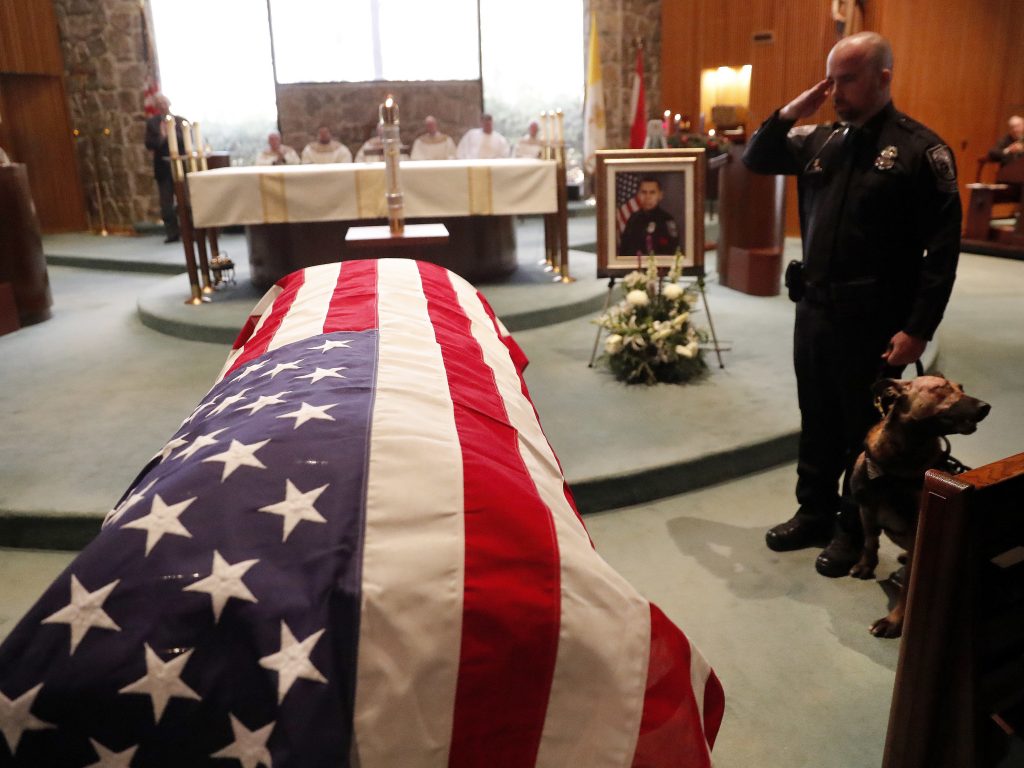As of Dec. 27, this year 144 federal, state and local law enforcement officers have died in the line of duty — a rise from the 129 officers killed in 2017. Here, wounded Dekalb County Police K9 Indi stands by his handler’s side during a funeral service for Edgar Flores on Dec. 18 in Georgia. As of Dec. 27, this year 144 federal, state and local law enforcement officers have died in the line of duty — a rise from the 129 officers killed in 2017. Here, wounded Dekalb County Police K9 Indi stands by his handler's side during a funeral service for Edgar Flores on Dec. 18 in Georgia. (John Bazemore/AP)