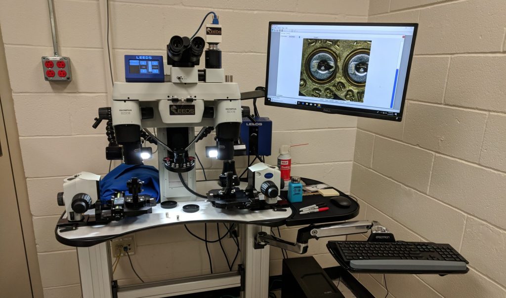 berks_nibin-1-e1544544055711-1920×1133 This high-powered microscope allows Berks County investigators to compare marks on shell casings to see if there may be a connection between gun crimes in the area. (Rachel McDevitt/WITF)