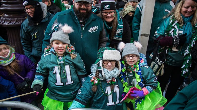 The Santora family stays warm and festive as they wait to cheer on their winning Eagles during the Super Bowl parade in Philadelphia Feb. 8, 2018. (Emily Cohen for WHYY)