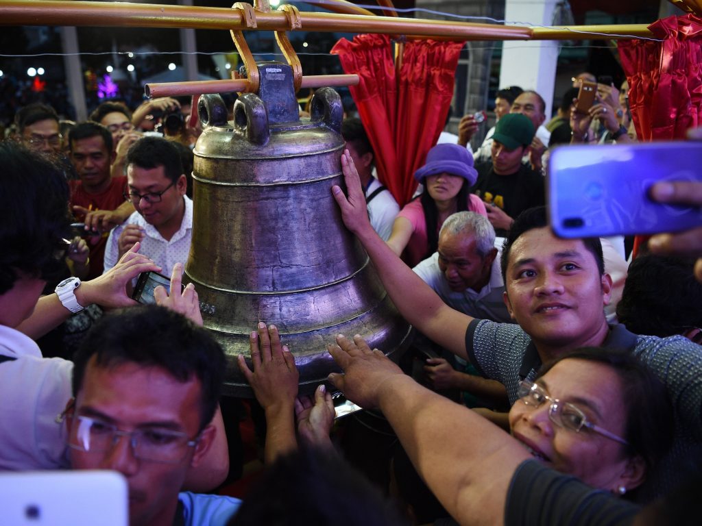 Residents take photos and try to touch one of the three Balangiga church bells after a ceremony returning them to the church in the town of Balangiga in the Philippines on Dec. 15, 2018. Residents take photos and try to touch one of the three Balangiga church bells after a ceremony returning them to the church in the town of Balangiga in the Philippines on Dec. 15, 2018. (Ted Aljibe/AFP/Getty Images)