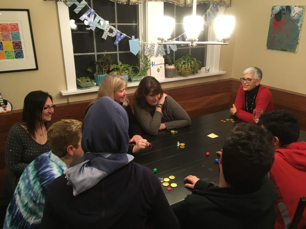 Tilko, a refugee from Iraq (at center with her back to the camera), at a Hanukkah celebration on Dec. 4, 2018, with the Jewish volunteers who helped her resettle in America. Tilko, a refugee from Iraq (at center with her back to the camera), at a Hanukkah celebration on Dec. 4, 2018, with the Jewish volunteers who helped her resettle in America. (Jerome Socolovsky/NPR)