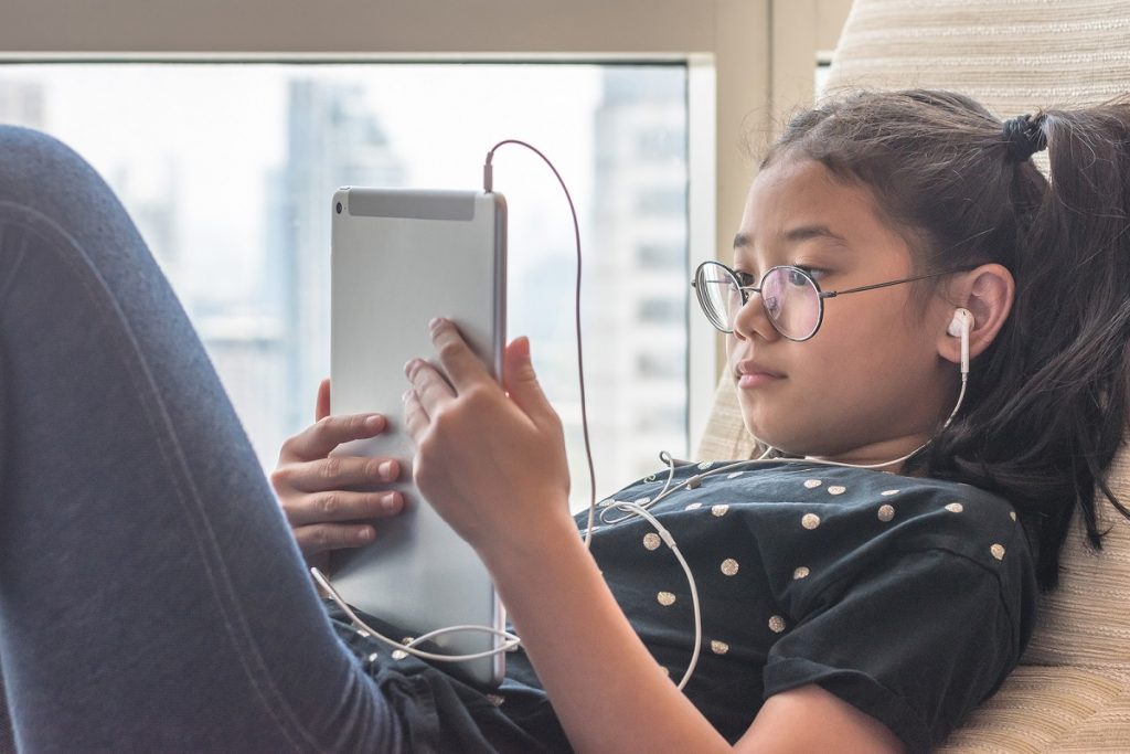 Digital Technology Lifestyle Of School Girl Child Or Student Usi Digital technology lifestyle of school girl child or student using wireless internet for distance learning application and reading e-book app on mobile ipad smart device multimedia computer tablet