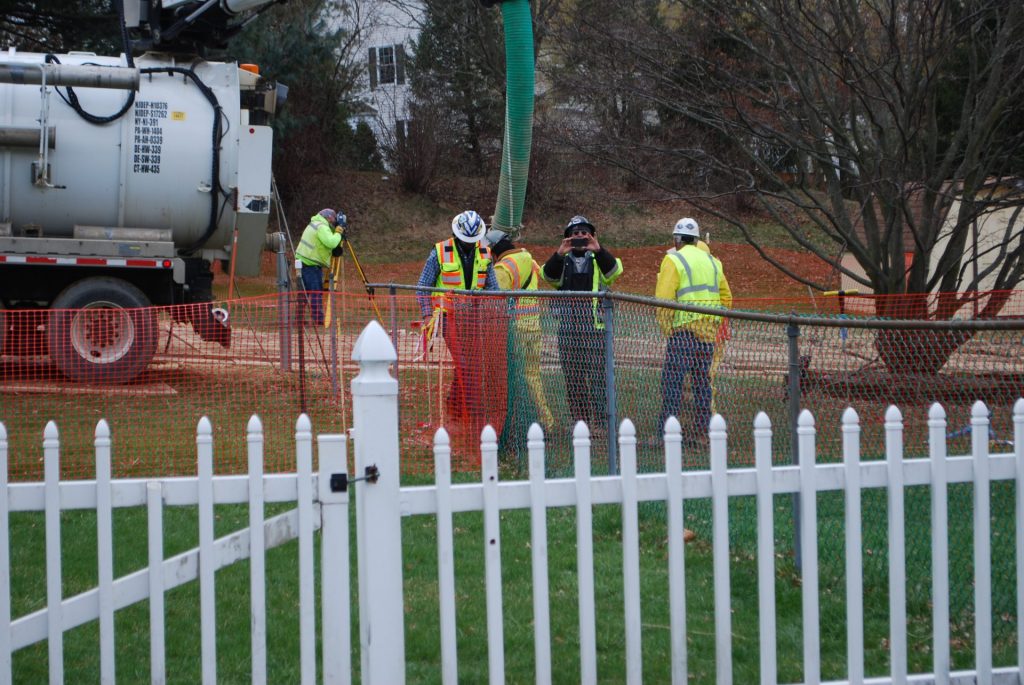2018-04-02-16.41.271-1920×1285 In this May 2018 photo, workers and contractors for Sunoco Pipeline investigate sink holes behind homes at Lisa Drive, West Whiteland Township, Chester County where the company has been drilling for construction of the Mariner East 2 and 2X pipelines. The company offered to relocate residents of the five homes whose yards are crossed by the pipeline right of way. (Jon Hurdle/StateImpact Pennsylvania)