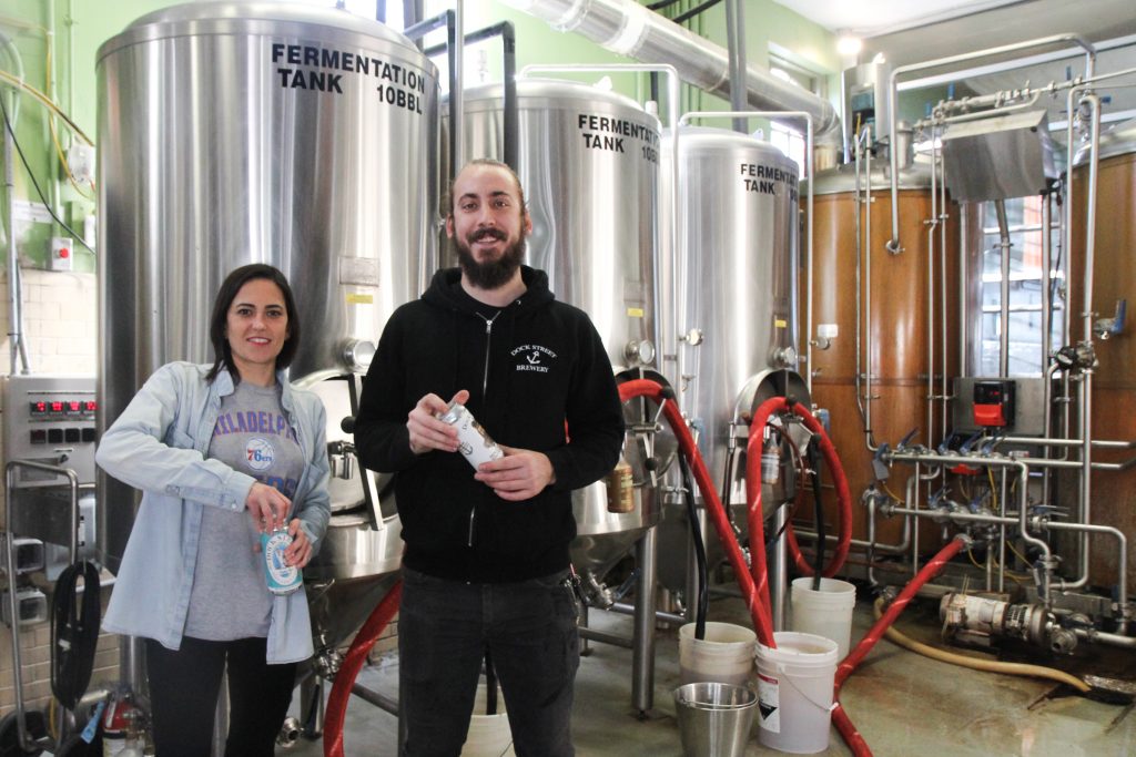 Dock Street Brewery Vice President Marilyn Candeloro (left) and brewer Mark Russell crack a beer. (Kimberly Paynter/WHYY)