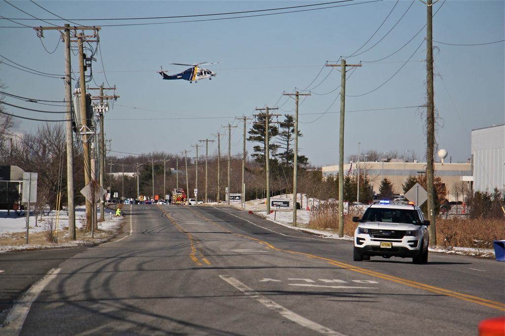 A state police helicopter lands near a UPS facility in Logan Township where two women were held hostage by a gunman. (Emma Lee/WHYY)