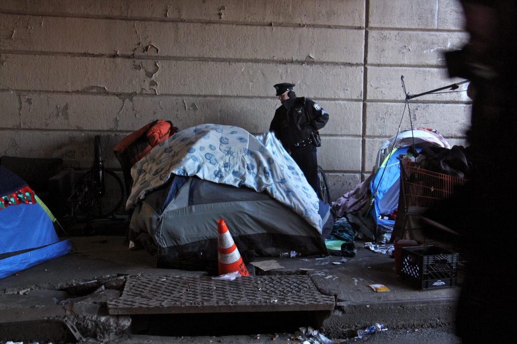 2019 01 31-e lee-philadelphia kensington emerald street-heroin encampment clear out A Philadelphia police officer moves from tent to tent telling residents of the Emerald Street encampment that it's time to go. (Emma Lee/WHYY)