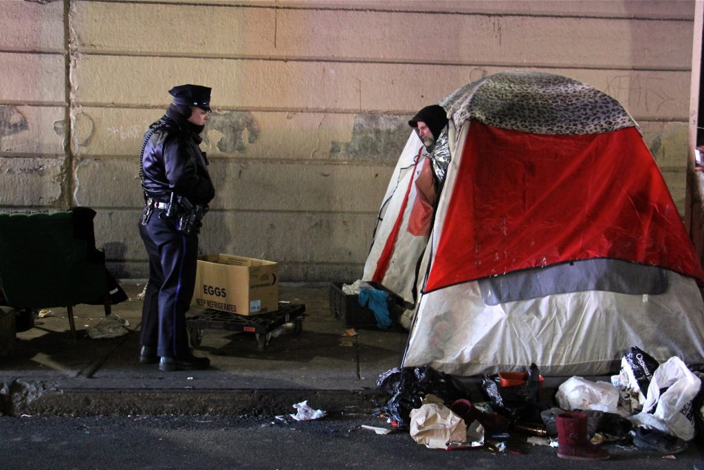 2019 01 31-e lee-philadelphia kensington emerald street-heroin encampment clear out A Philadelphia police officer moves from tent to tent telling residents of the Emerald Street encampment that it's time to go. (Emma Lee/WHYY)