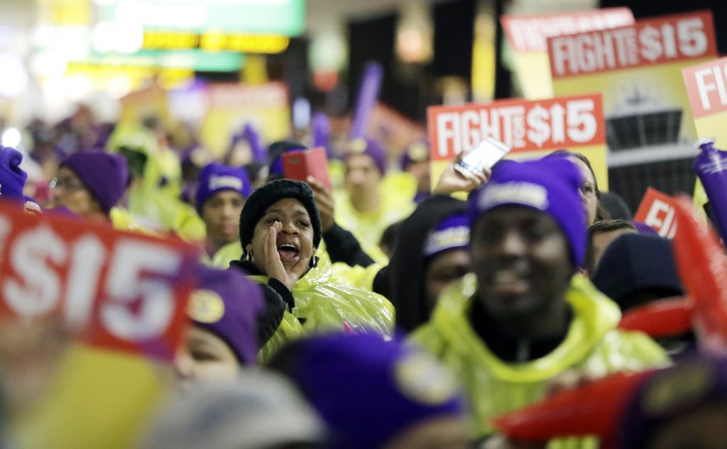 Newark Minimum Wage Rally In this file photo, a woman shouts while marching with service workers asking for $15 minimum wage pay during a rally at Newark Liberty International Airport, Tuesday, Nov. 29, 2016, in Newark, N.J. (Julio Cortez/AP Photo)