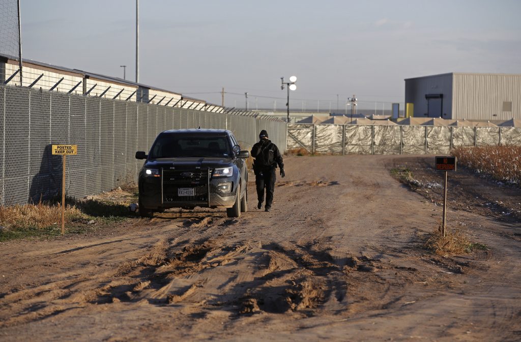 Texas Immigration Shelter In this file photo, a private security guard patrols outside the Tornillo detention camp for migrants in Tornillo, Texas, Thursday Dec. 13, 2018. (Andres Leighton/AP Photo)