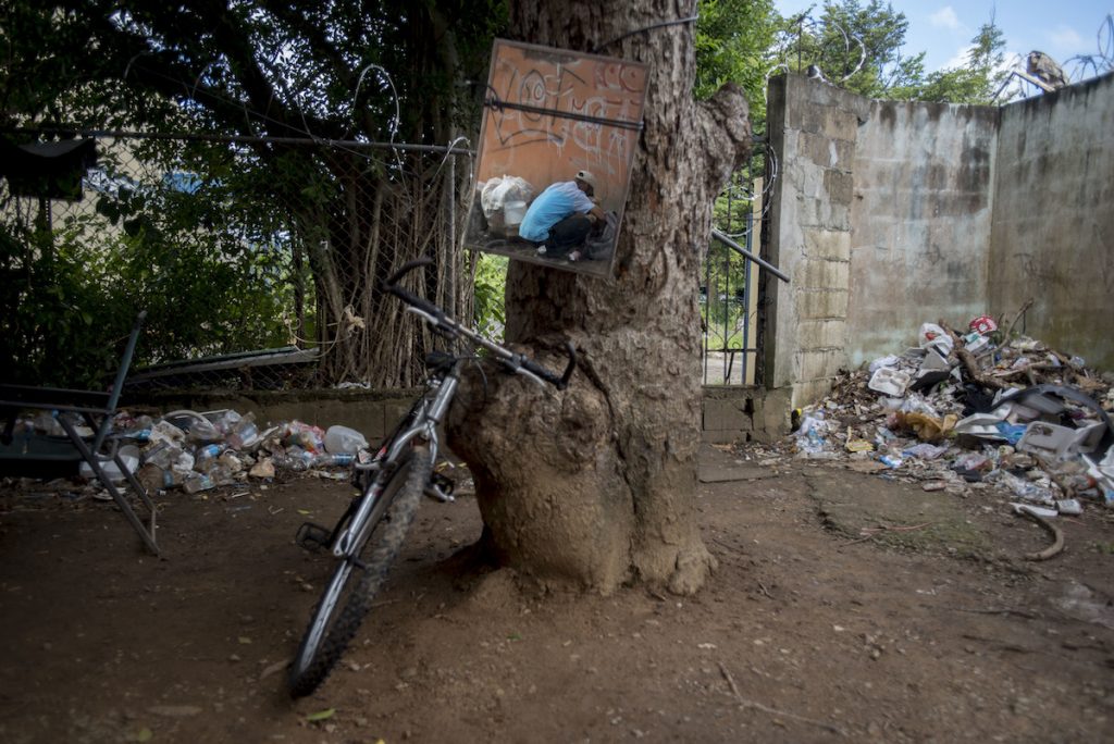 Puerto Rico Opioid Crisis In this Dec. 14, 2018 photo, a mirror tied to a tree reflects a heroin user preparing his dose, in an area popular for people with a drug addiction behind an abandoned home in Humacao, Puerto Rico. Heroin users will often use the mirror to get a better view of themselves when injecting, especially when into their necks. (AP Photo/Carlos Giusti)