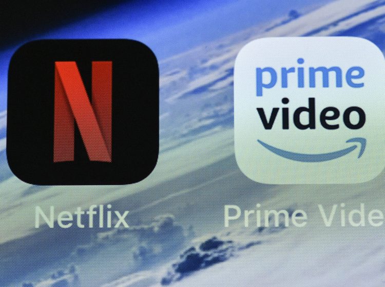 In this Thursday, Nov. 15, 2018 file photo, the icons of streaming services Netflix and AmazonPrime Video are pictured on an iPhone in Gelsenkirchen, Germany. Streaming your favorite movies and TV shows is about to get way more expensive. Amazon Prime customers can add-on subscriptions to HBO, Showtime or Starz. (Martin Meissner/AP Photo, File)