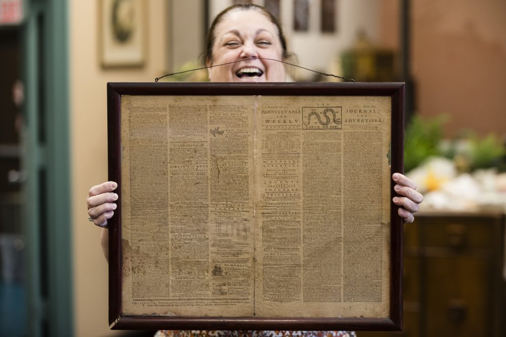 In this Thursday, Oct. 25, 2018 file photo, Heather Randall displays a Dec. 28, 1774 Pennsylvania Journal and the Weekly Advertiser at the Goodwill Industries South Jersey in Bellmawr, N.J.  An original 1774 Philadelphia newspaper that was discovered at a New Jersey Goodwill is heading to a Philadelphia philosophy society founded by Benjamin Franklin. (Matt Rourke/AP)