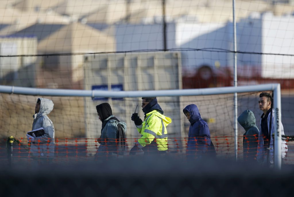 In this Dec. 13, 2018, file photo, teen migrants walk in line inside the Tornillo detention camp in Tornillo, Texas. Government investigators say many more migrant children may have been separated from their parents than the Trump administration has acknowledged.  (Andres Leighton/AP)