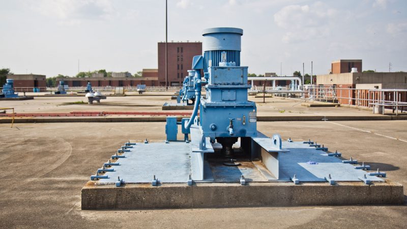 The blue aeration tanks were added when the plant upgraded to secondary treatment, as required by the Clean Water Act. The primary effluent is added to the tank with microbes and oxygen. The microbes eat up the bacteria in the water, get bigger and bigger, and eventually settle to the bottom. Some of what settles is recycled for future aeration cycles, and the rest is sent to anaerobic digesters along with the sludge from primary treatment to make renewable energy and fertilizer. (Kimberly Paynter/WHYY)