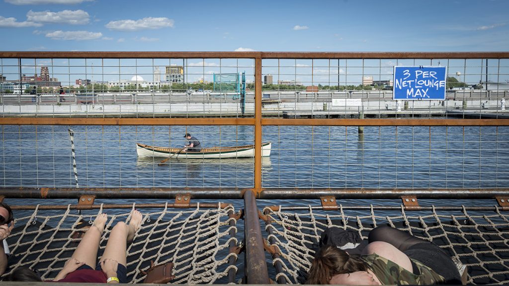 Spruce Street Harbor Park Opens to Publict People now use the Delaware for recreation, like these visitors to Spruce Street Harbor Park. Prior to the Clean Water Act, the Delaware River was so polluted no one would have considered basking so close to it. But the regulation has not been updated for decades, and scientists say hidden dangers to fish and wildlife still exist. (Brandon Eastwood for WHYY)