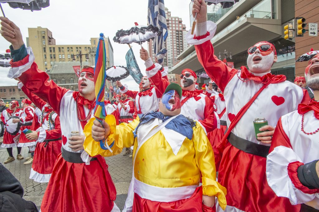 Members of Cara Leom sing along as their band plays Golden Slippers at Broad and Spruce Streets. (Jonathan Wilson for WHYY)