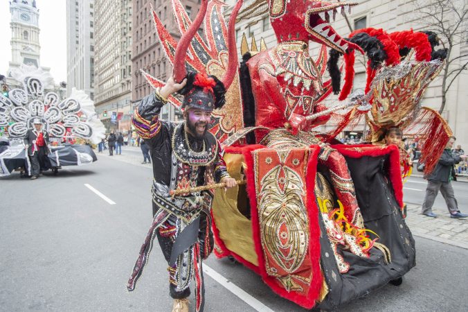 Brian Creamer struggles to keep his Golden Sunrise float stable as he heads into wind gusts on Broad St. (Jonathan Wilson for WHYY)