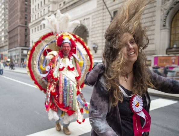 Amber Hawk's hair covers her face as she heads into wind gusts on Broad St. She is a member of the Fancy Division's Golden Sunrise.(Jonathan Wilson for WHYY)