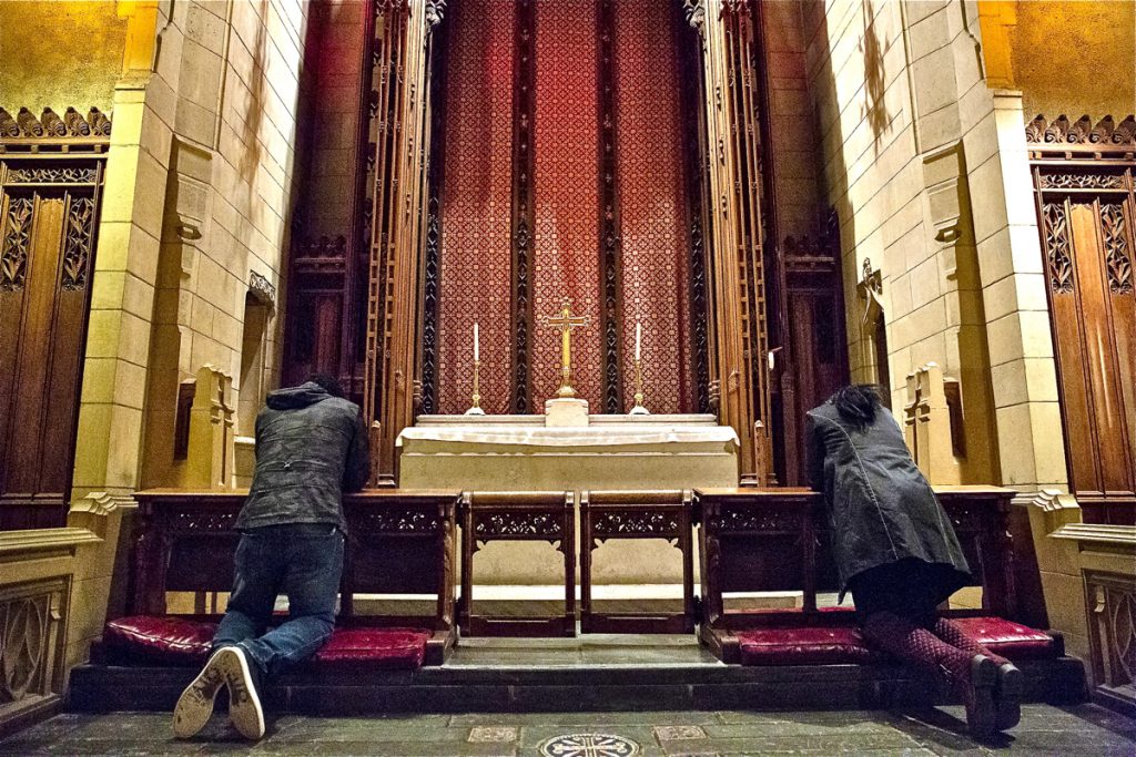 Oneita Thompson prays next to her husband, Clive, left, inside the First United Methodist Church of Germantown on Monday, Nov. 12, 2018. The couple is from Jamaica and has lived in the United States since 2004. They moved from their home in Cedarville, New Jersey, into the church last year, bringing their two youngest children, Christine, 16, and Timothy, 12, with them. (Heather Khalifa/The Philadelphia Inquirer)