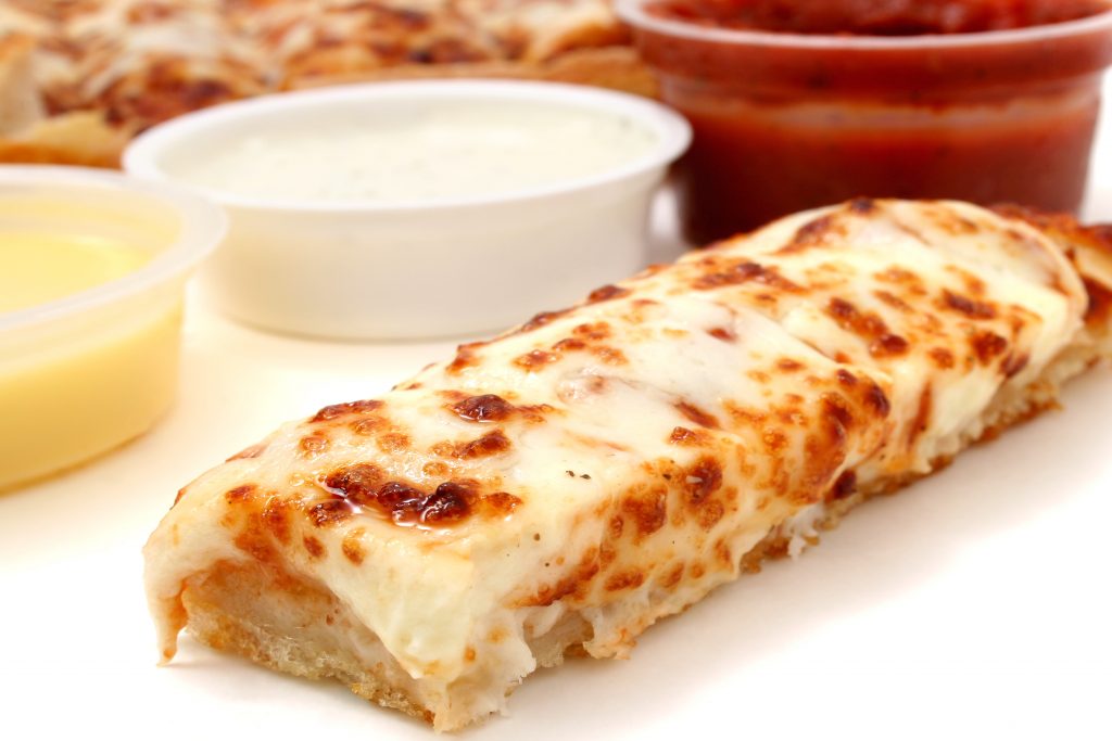 Pizza Sticks And Marinara Sauce, Garlic Sauce And Ranch Dressing A new study shows that for a quarter of Americans, eating at work adds as much as 1,300 calories per week — most of them empty. (Duplass/BigStock)