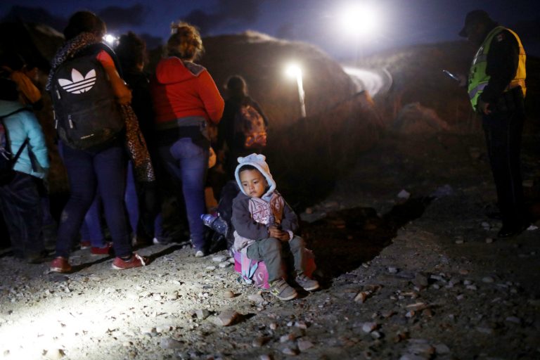 A group of Honduran migrants are detained along the U.S.-Mexico border by Mexican police after attempting to cross the border barrier into the U.S. (Mario Tama/Getty Images)