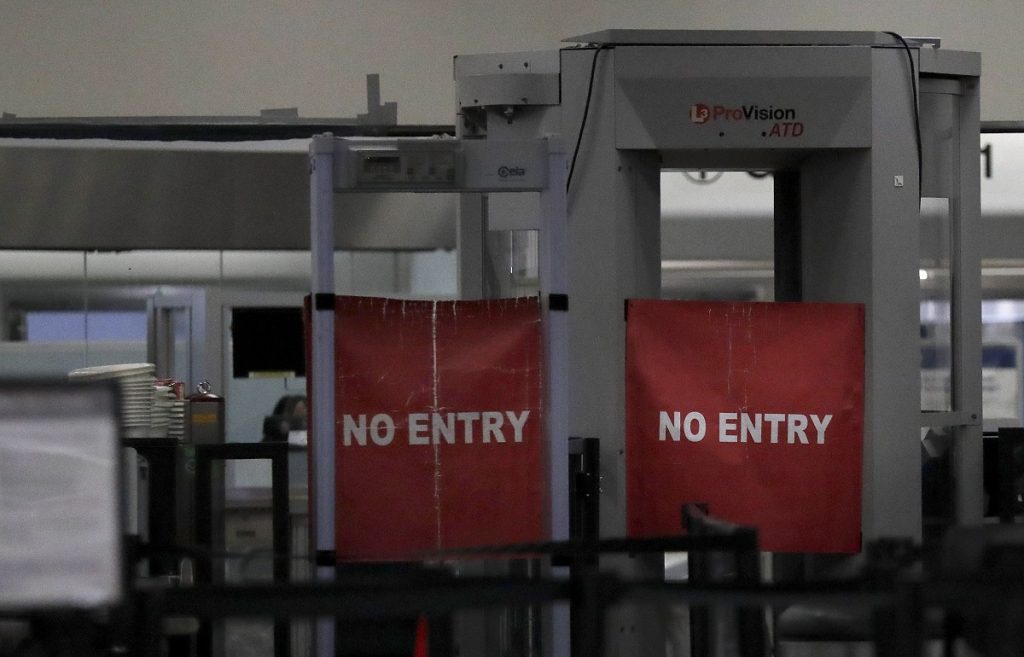 Government Shutdown Airport Terminal Travelers are permitted from entering a closed down terminal at the Miami International Airport on Saturday, Jan. 12, 2019, in Miami. The partial government shutdown is starting to strain the national aviation system, with unpaid security screeners staying home, air-traffic controllers suing the government and safety inspectors off the job. (Brynn Anderson/AP Photo)