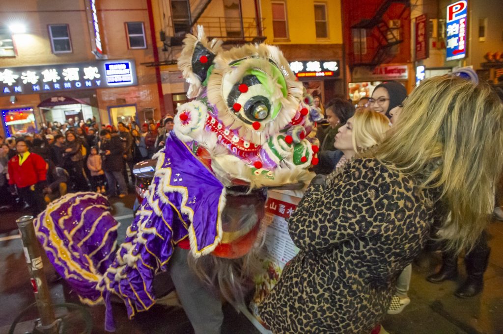 11CHINESE NEW YEAR 2019 A woman blows a kiss to one of the lions dancing on Race Street during the Chinese New Year celbration. (Jonathan Wilson for WHYY)