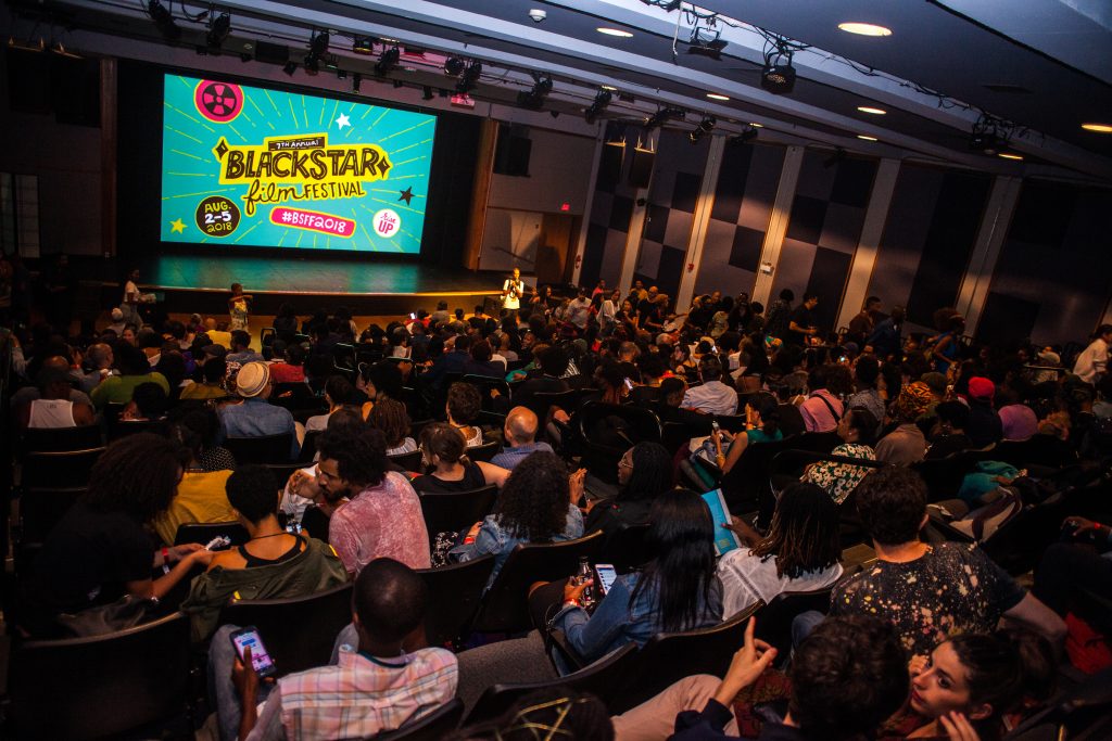 Audience members look towards a screen that says 