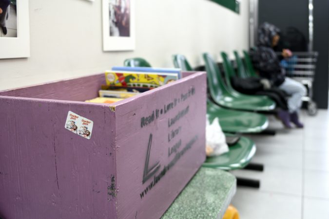 Childrens' books are available from this little library to read during the wait at the laundromat owned and operated by James Betterson, in Northeast Philadelphia. (Bastiaan Slabbers for WHYY)