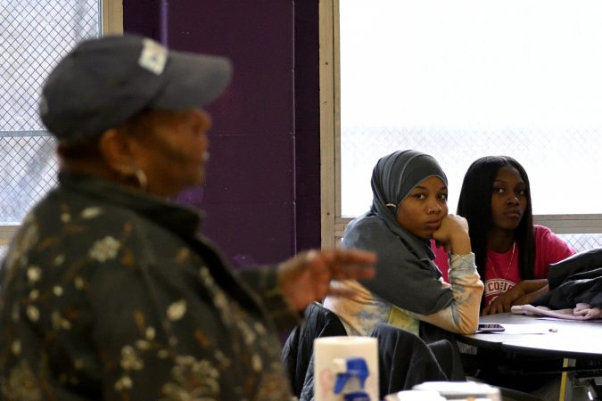 MLK Tenth-grader Taniyah Fulton (center) and a fellow student listen to coach Lurline Jones. Ms. Jones coaches a girls basketball team with students from MLK and Lankenau High Schools. (Bastiaan Slabbers for WHYY)