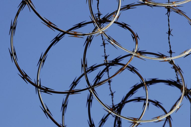 In this Tuesday, Oct. 23, 2018 photo, barbed wire lines the top of a wall at the deactivated House of Correction in Philadelphia. (Matt Rourke/AP Photo)