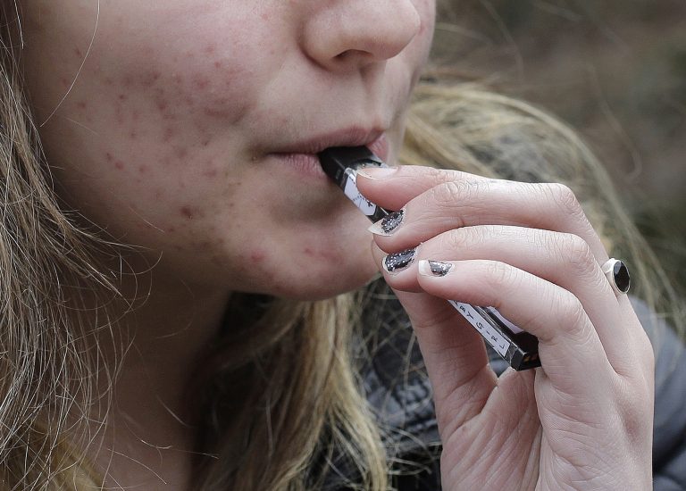 In this April 11, 2018 file photo, a high school student uses a vaping device near a school campus in Cambridge, Mass. (Steven Senne/AP Photo)