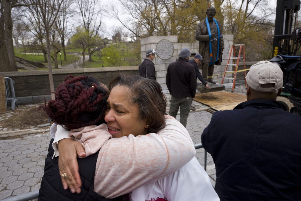 Dr. Bernadith Russell, Dr. J. Marion Sims In this Tuesday, April 17, 2018, file photo, Dr. Bernadith Russell hugs a friend as the statue of Dr. J. Marion Sims, is removed from New York's Central Park. (Mark Lennihan/AP Photo, File)