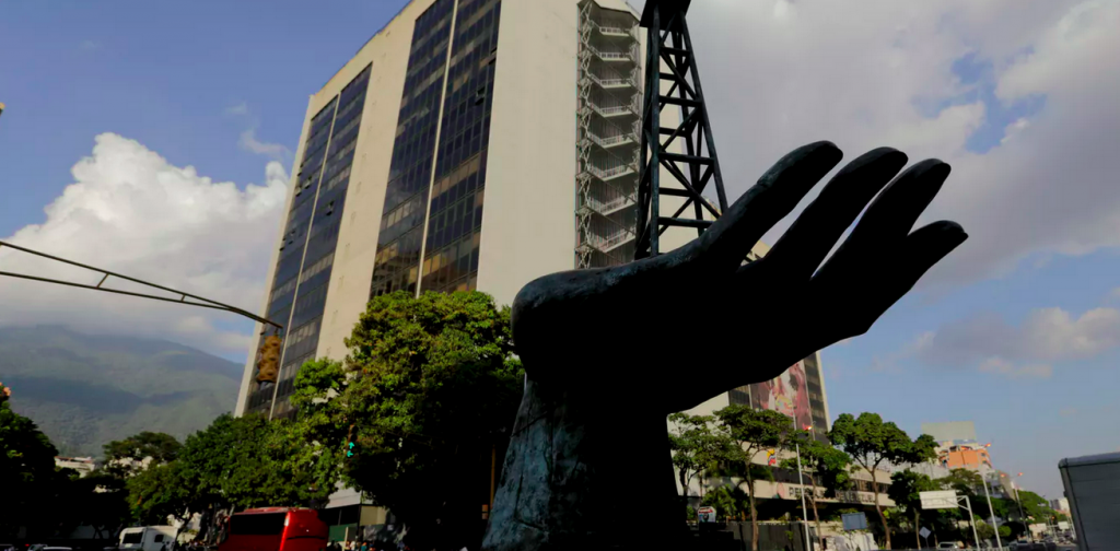 Screen Shot 2019-02-09 at 11.04.54 AM A sculpture of an oil pump held by a human hand stands outside the headquarters of Venezuela’s state-owned oil company. (Fernando Llano/AP Photo)