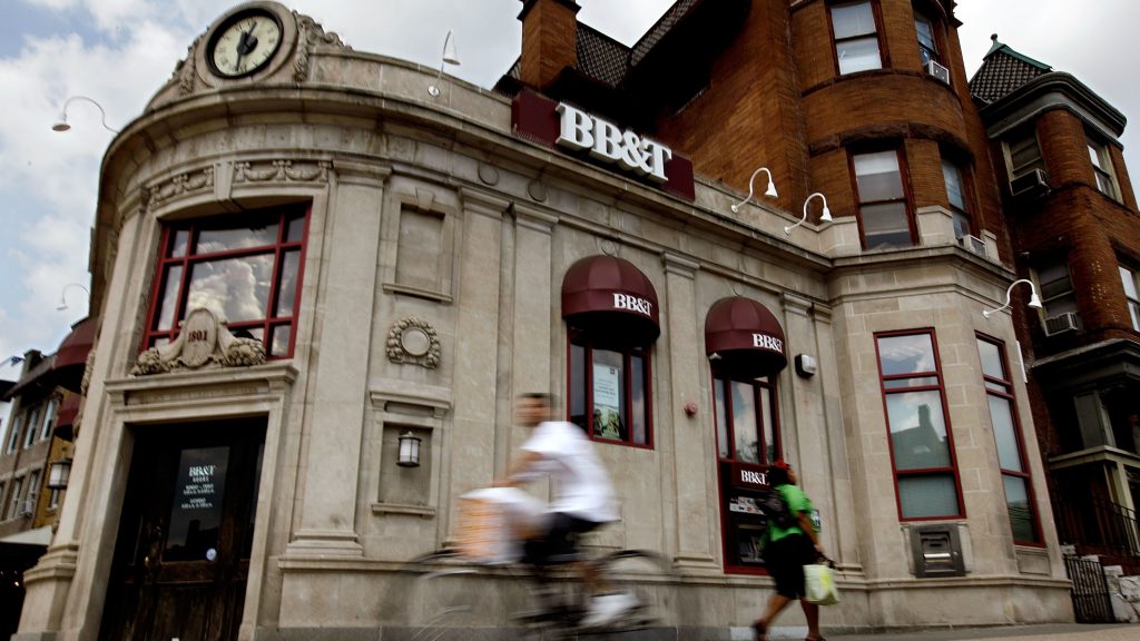 BB&T is merging with SunTrust, in a deal worth some $66 billion. Here, people walk past a BB&T branch in a file photo from Washington, D.C. (Chip Somodevilla/Getty Images)