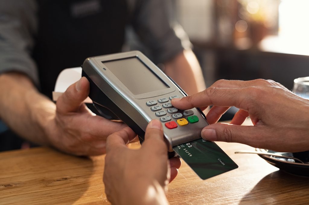 Closeup of hand using credit card swiping machine to pay. Female Some businesses will only allow credit card transactions. (Rido81/BigStock)