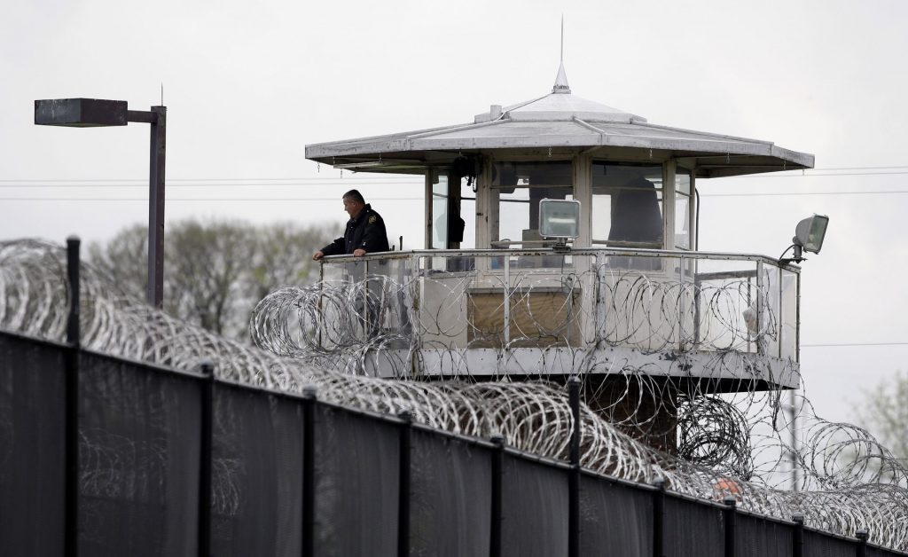 A solitary corrections officer looks out from a tower at one corner of the state prison in Camp Hill. (Carolyn Kaster/AP Photo) 