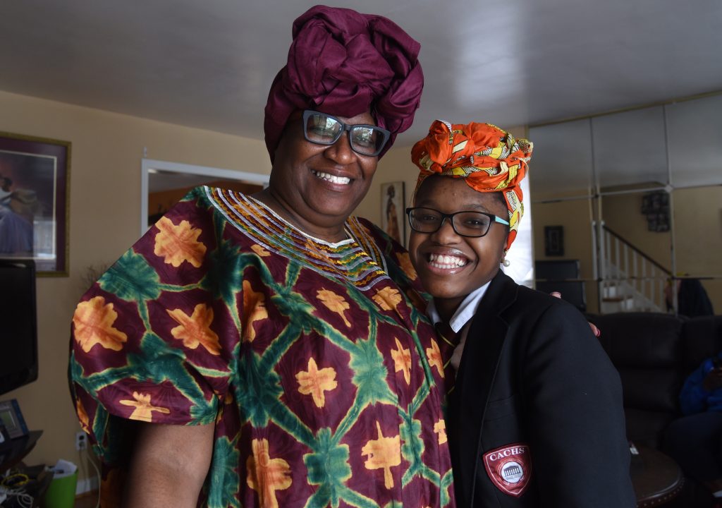 geniah2 Geniah Miller in her Camden Academy Charter High School uniform and the Nigerian head wrap with her mother, Chioma Sullivan, at their Camden home on Feb. 11, 2019, after Miller was sent home from school. (April Saul for WHYY)